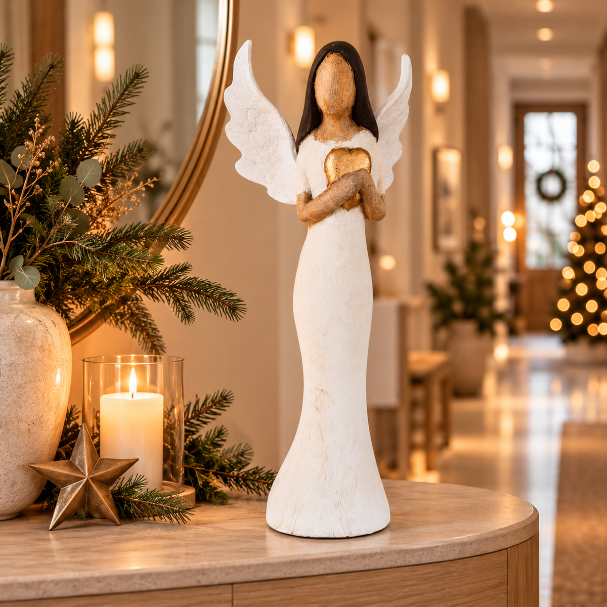 Große Weihnachtsengel-Figur modern in weiß goldener Holzoptik mit Herz stehend auf einer Kommode mit Adventsdeko.